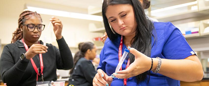 学生 working with syringes in classroom.